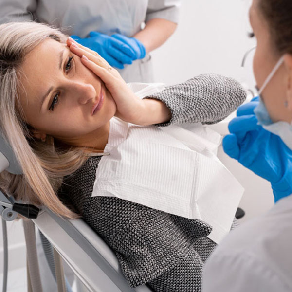 beautiful caucasian girl with toothache sits in a dental chair. Professional dentist helps his female patient in pain.painful treatment help. Dr Eberhardt Performing Exam