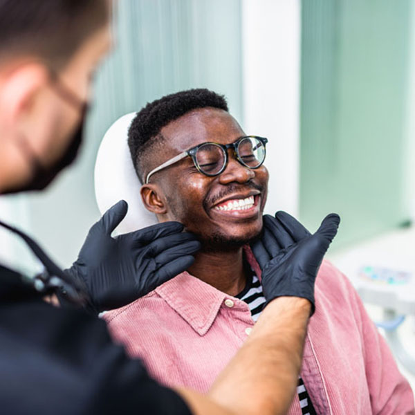 African American young man having a visit at the dentist's. He i Dr Eberhardt Performing Exam